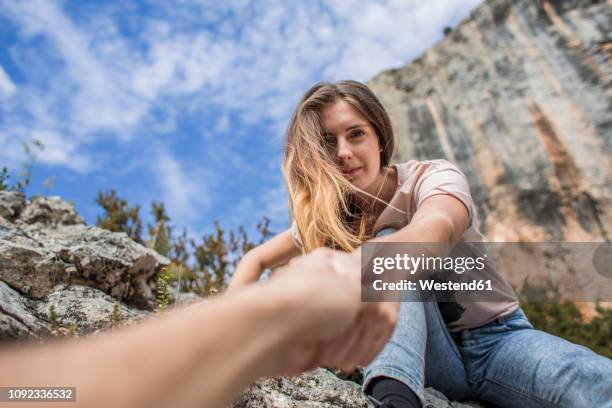 spain, alquezar, young woman on a hiking trip giving a helping hand - 異常角度 個照片及圖片檔