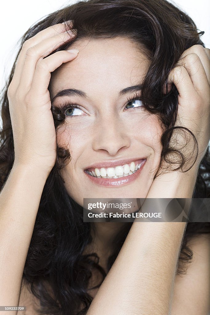 Young woman smiling with hands in hair