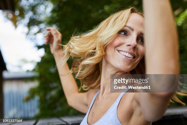 carefree blond woman outdoors - arm pit stockfoto's en -beelden