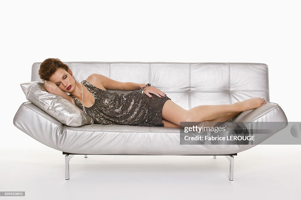 Young woman in formalwear sleeping on sofa