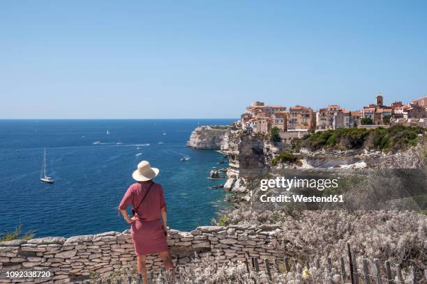 corsica, bonifacio, woman standing on viewpoint looking to the city - bonifacio stock pictures, royalty-free photos & images