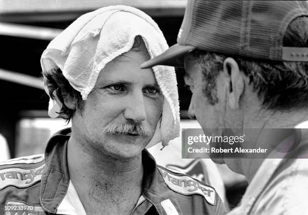 Dale Earnhardt Sr. Cools down and talks with Bobby Allison in the Daytona International Speedway garage after completing the 1985 Firecracker 400 on...
