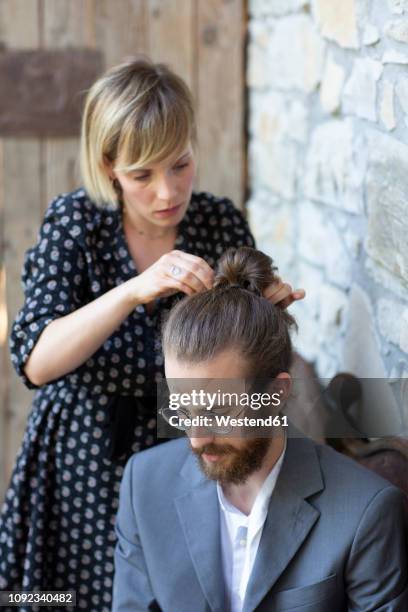 woman doing hair of young man in grey suit - special hair stock pictures, royalty-free photos & images