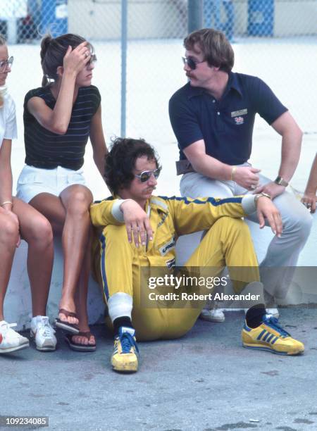 Dale Earnhardt Sr, driver of the Wrangler Ford Thunderbird, relaxes on pit road, with his wife Teresa and others, during qualifying for the 1982...