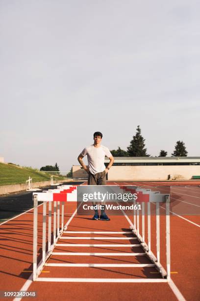 young runner preparing for hurdle race - hürdenlauf stock-fotos und bilder