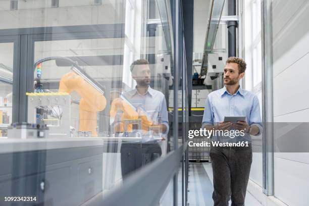 businessman checking robots with digital tablet in high tech company - effet miroir homme photos et images de collection