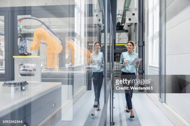 businesswoman checking robots with digital tablet in high tech company - manufacturing technology bildbanksfoton och bilder