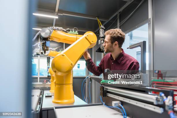 businessman checking industrial robot in high tech company - robot hand stock pictures, royalty-free photos & images