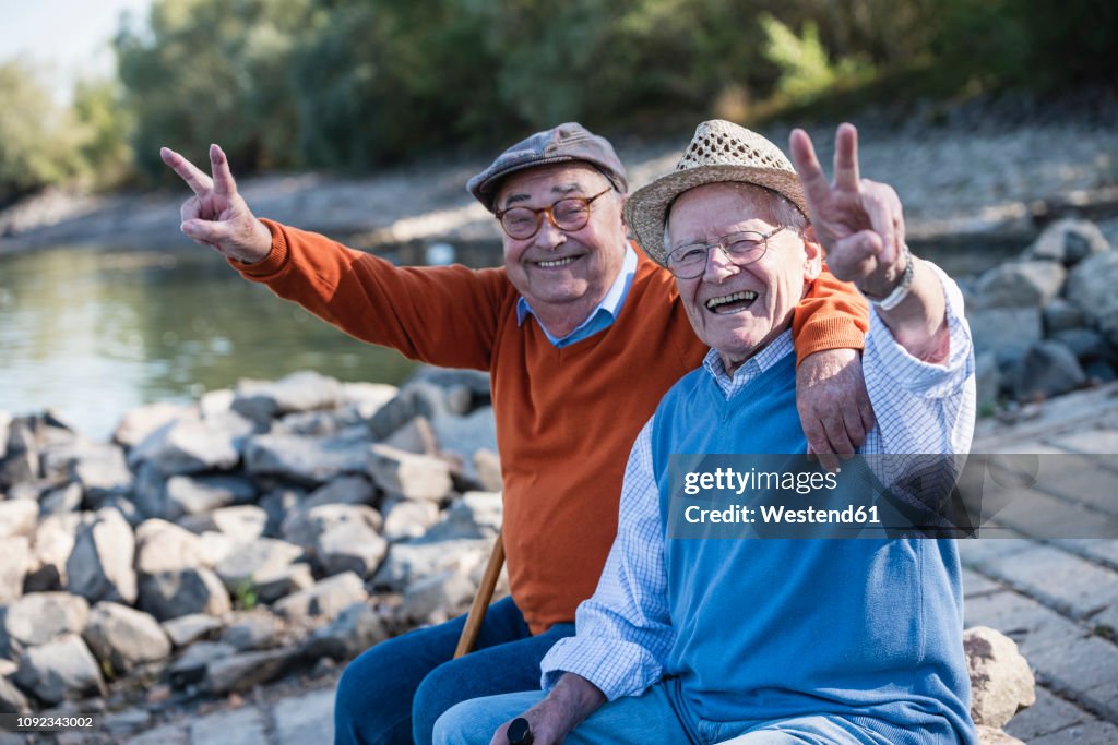 Two old friends sitting by the riverside, having fun