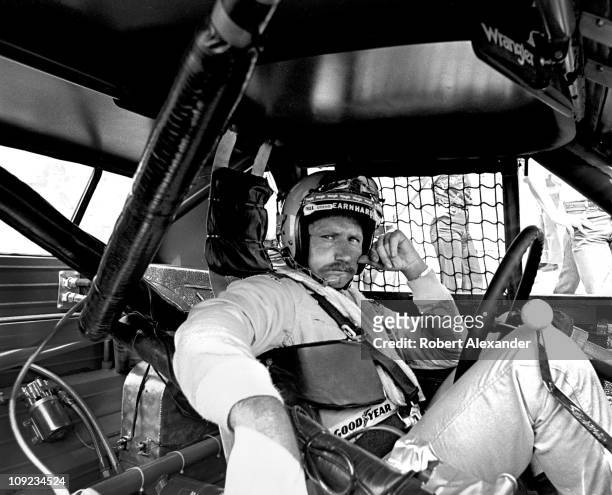 Dale Earnhardt Sr sits in his Wrangler Pontiac Grand Prix while it is repaired after an accident during the 1981 Firecracker 400 at the Daytona...