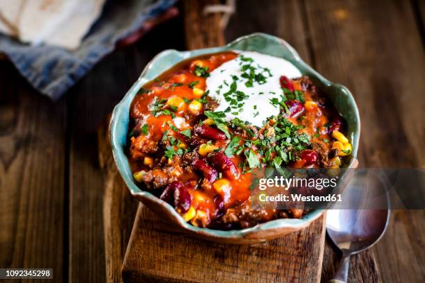 chili con carne with kidney beans and corn, sour cream, parsley, tortilla bread - bowl chili peppers bildbanksfoton och bilder