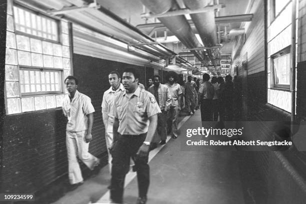 Corrections officer leads a group of inmates down the hallway of the Cook County Jail, Chicago, IL, 1972.