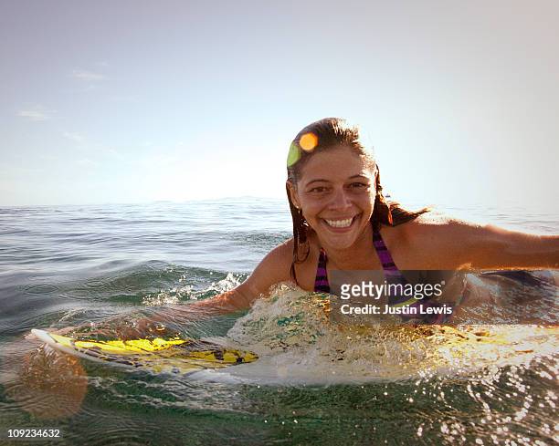 female surfer smiling while on her surf board. - fiji people stock pictures, royalty-free photos & images