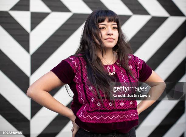 close up young latina wears magenta ethnic top, stands confidently with hands on hips, body positive - us kultur stock-fotos und bilder