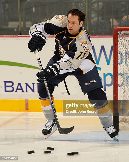 David Legwand of the Nashville Predators clears pucks from the net during warmups against the Vancouver Canucks during an NHL game on February 17,...