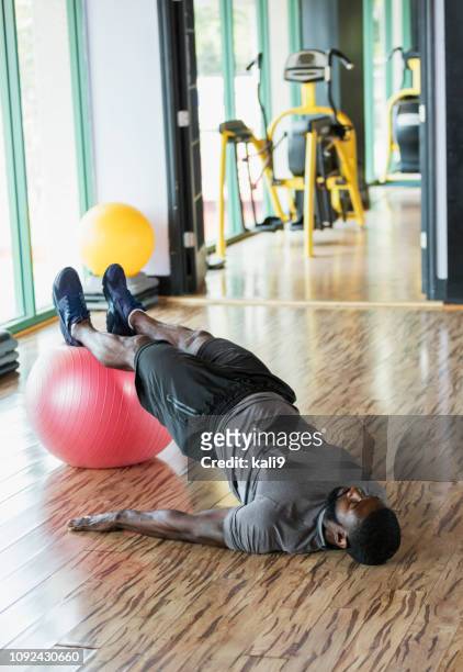 mid adult african-american man working out at gym - gym excercise ball stock pictures, royalty-free photos & images
