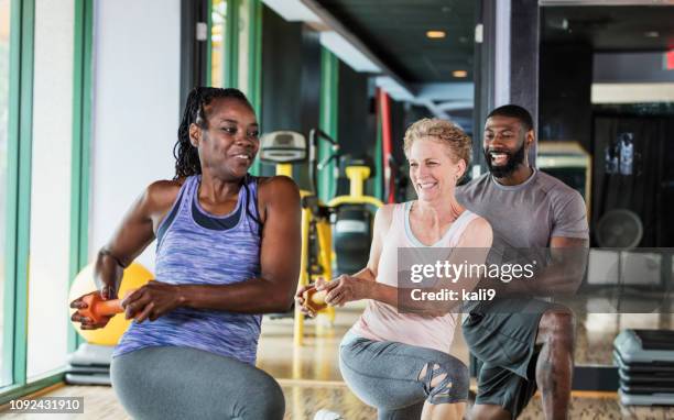 grupo de personas en el gimnasio va estocadas - mature coach fotografías e imágenes de stock