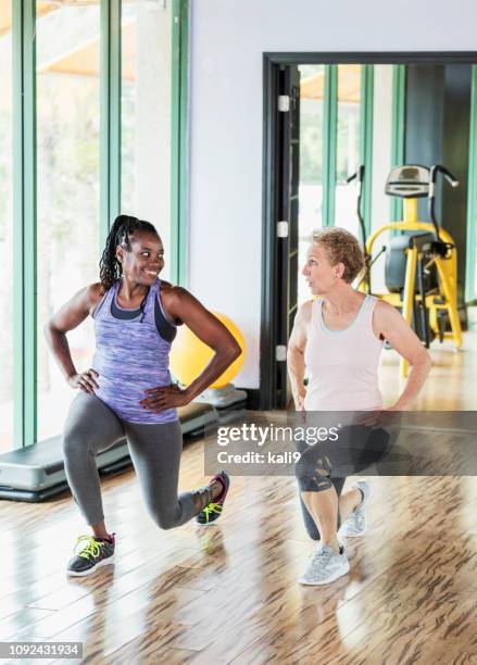 two women  in gym doing lunges - hand on hip stock pictures, royalty-free photos & images