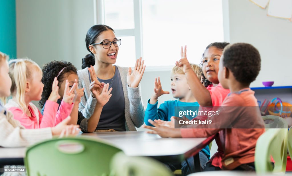 Multi-ethnic preschool teacher and students in classroom
