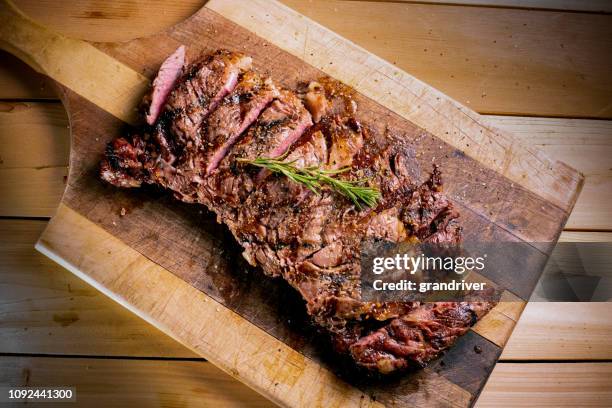 gegrilde ribeye steak op een snijplank - rib eye steak stockfoto's en -beelden