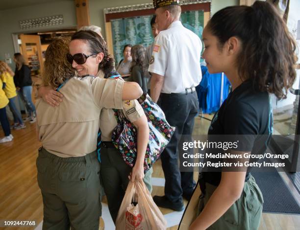 Troop leaders Monique Chrisope and Dea Del Rosario greet each other with a hug before a ceremony to submit an application for the county's first...