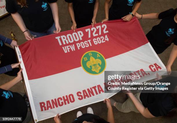 Eight of the 22 founding members of Boy Scout Troop 7272 stand around the new Troop flag for a portrait after a ceremony to submit an application for...