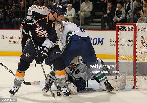 Roberto Luongo of the Vancouver Canucks scrambles to cover a loose puck against David Legwand of the Nashville Predators during an NHL game on...