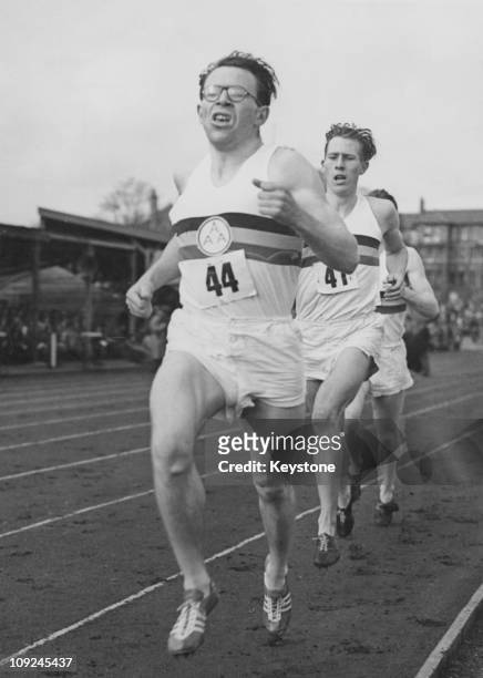 British athlete Chris Brasher runs ahead of Roger Bannister, during the first lap of Bannister's record-breaking sub-4-minute mile run at Iffley...