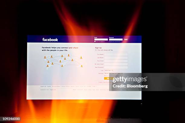 The Facebook website is seen through fire on a computer screen in this photo arranged in Beijing, China, on Thursday, Feb. 17, 2011. Facebook Inc....