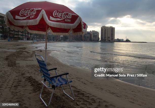 el arte de colocar la sombrilla,... el primero - sombrilla playa stock pictures, royalty-free photos & images