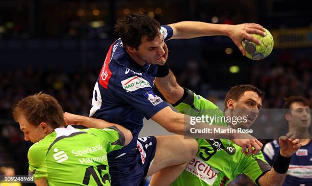 Pascal Hens of Hamburg is challenged by Piotr Przybecki of Hannover-Burgdorf during the Toyota Handball Bundesliga match between HSV Hamburg and...