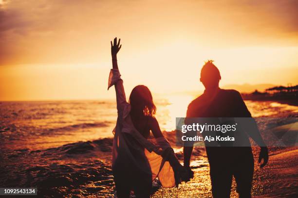 groeten aan de zon. - couple sunset stockfoto's en -beelden