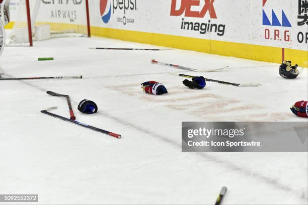 Hockey gloves and hockey sticks lay all over the ice after an end of game fight between both teams after the Calgary Flames vs. The Washington...