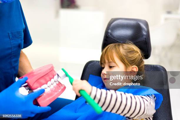 dentista che insegna ragazza carina sull'igiene orale - dentista bambini foto e immagini stock