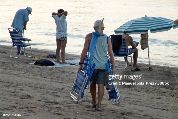 el arte de colocar la sombrilla xliv - sombrilla de playa stockfoto's en -beelden