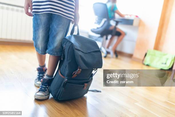 jongen holding rugzak weg, lage sectie verplaatsen - backpacks stockfoto's en -beelden