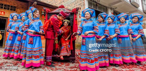 Couple of couples wore traditional Zhuang costumes to hold a wedding. They carried sedan chairs to the villages to meet the bride. They were unique...