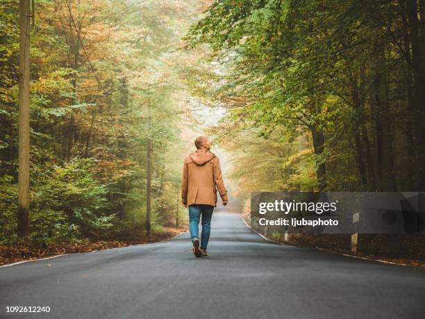 enjoying a solitary walk - men walking stock pictures, royalty-free photos & images