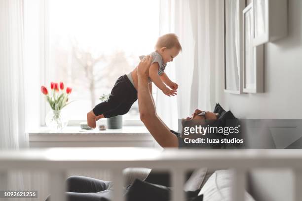 stay at home father with his baby son - flying dad son stock pictures, royalty-free photos & images