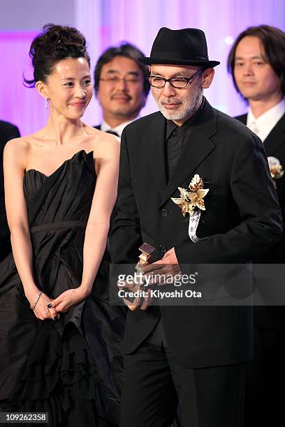 Director Tetsuya Nakashima holds a trophy on stage beside actress Yoshino Kimura as he accepts the Best Picture award for 'Kokuhaku' during the 34th...