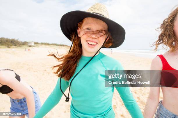 teenage friends enjoy each others company whilst playing, running and talking on an australian beach - sunshine coast australia stock pictures, royalty-free photos & images