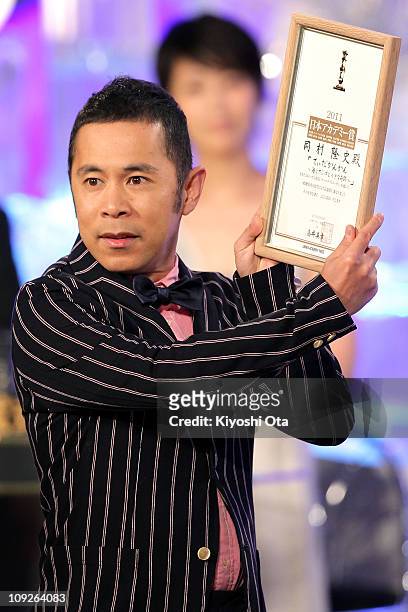 Actor and comedian Takashi Okamura accepts the award for Most Popular Actor for 'Tida-kankan: Umi to sango to chiisana kiseki ' onstage during the...