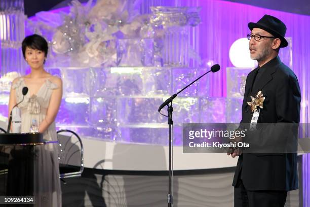 Director Tetsuya Nakashima speaks onstage as he accepts the award for Best Director for 'Kokuhaku ' while cast member Takako Matsu looks on during...