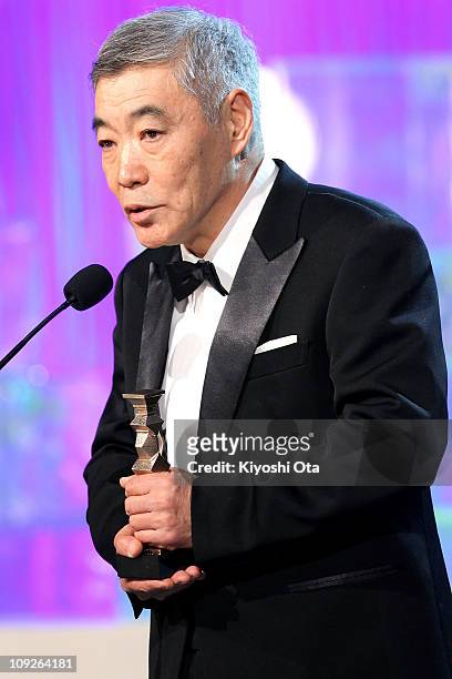 Actor Akira Emoto speaks on stage as he accepts the award for Best Actor in a Supporting Role for 'Akunin ' during the 34th Japan Academy Awards at...