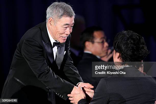 Actor Akira Emoto shakes hands with director Lee Sang-il as he accepts the award for Best Actor in a Supporting Role for 'Akunin ' during the 34th...
