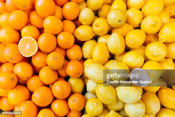 fresh oranges and lemons on a market stall - citrus fruit background stock pictures, royalty-free photos & images