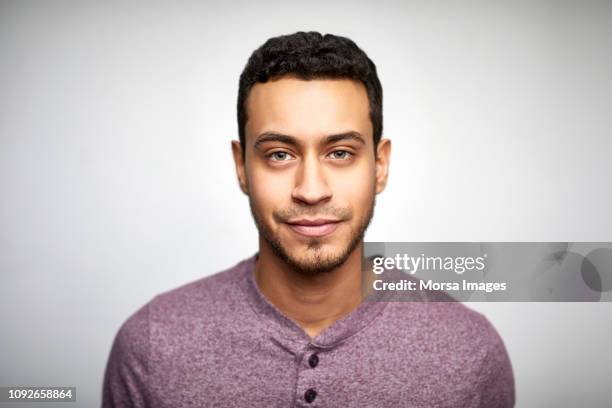 confident young man wearing purple t-shirt - 20s confident young male stockfoto's en -beelden