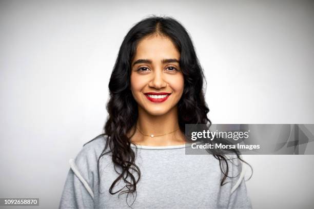 young woman smiling against white background - one mid adult woman only ストックフォトと画像