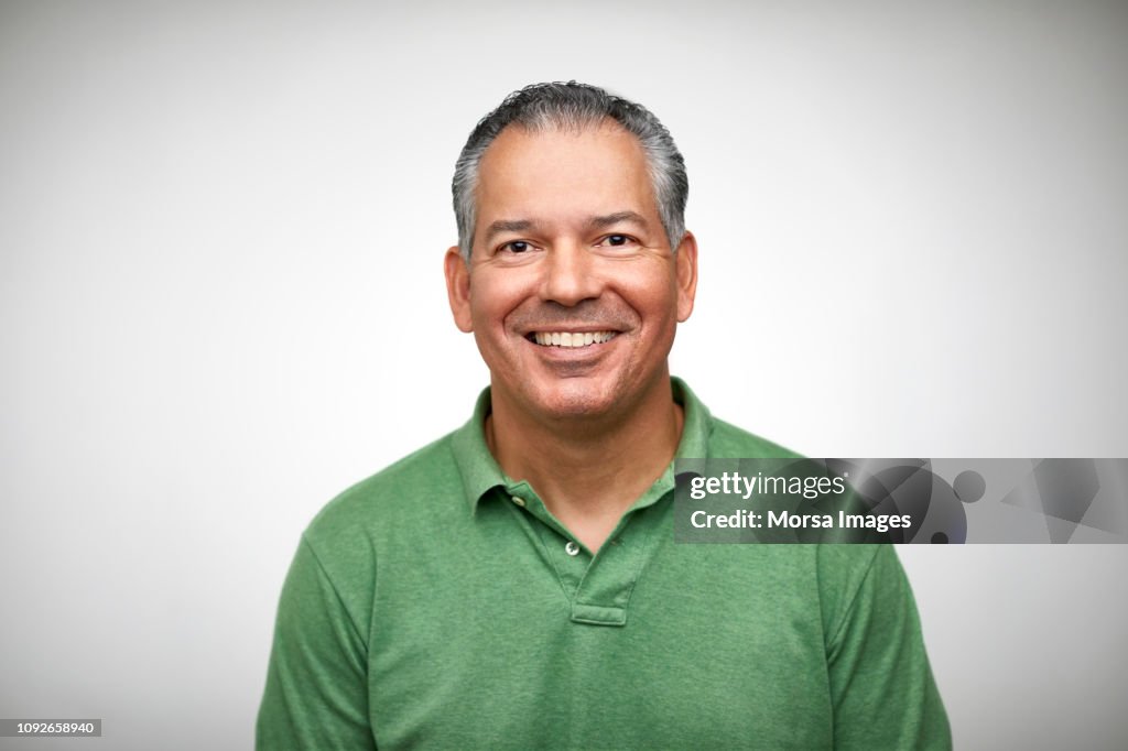 Portrait of mature man smiling against white