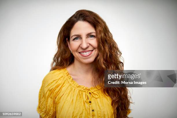 smiling mid adult woman with long wavy hair - einzelne frau über 30 stock-fotos und bilder